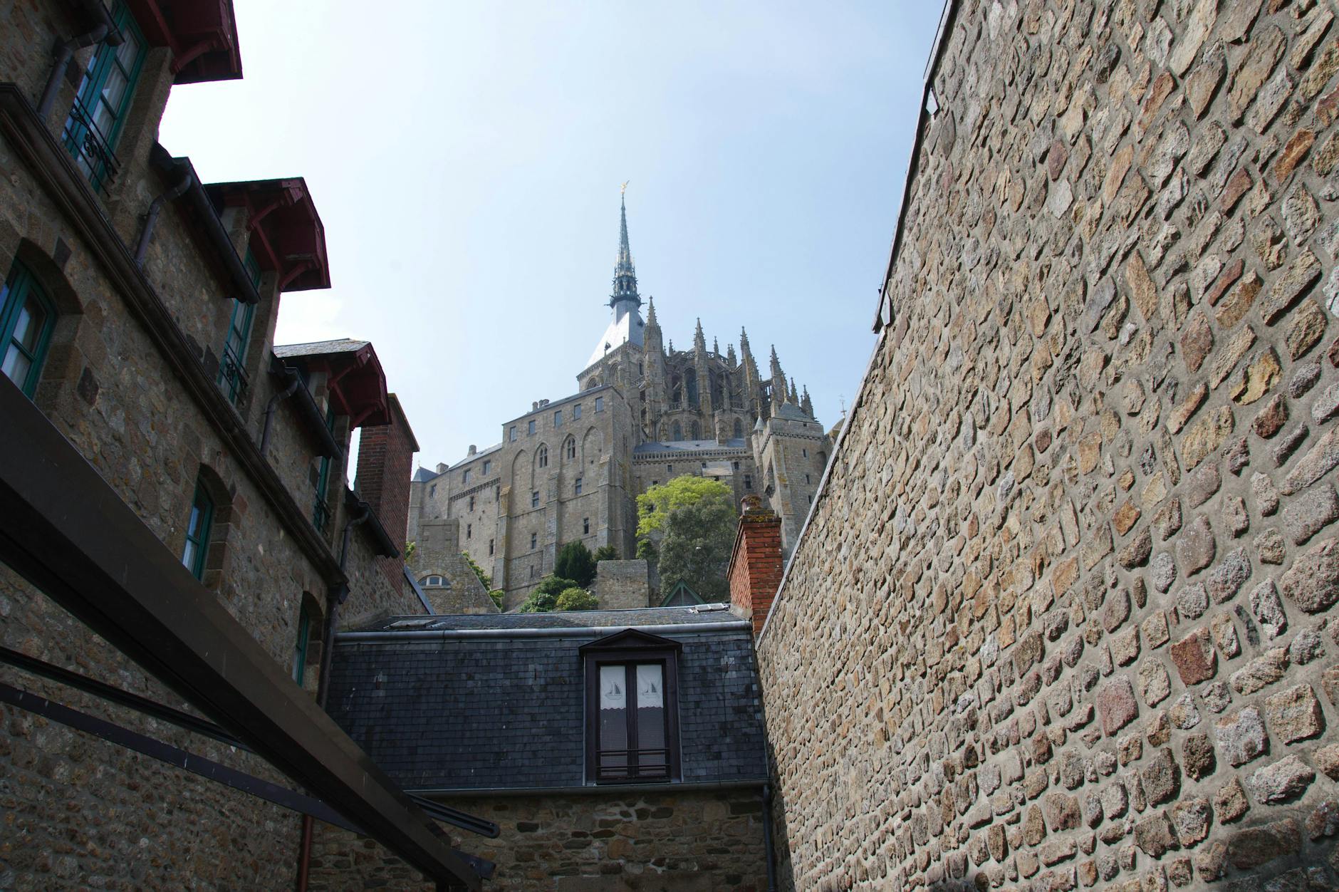 Stone walls framing Mont Saint-Michel Abbey against clear blue sky