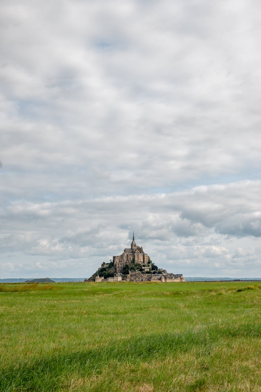 Mont Saint-Michel in the distance across green Normandy fields