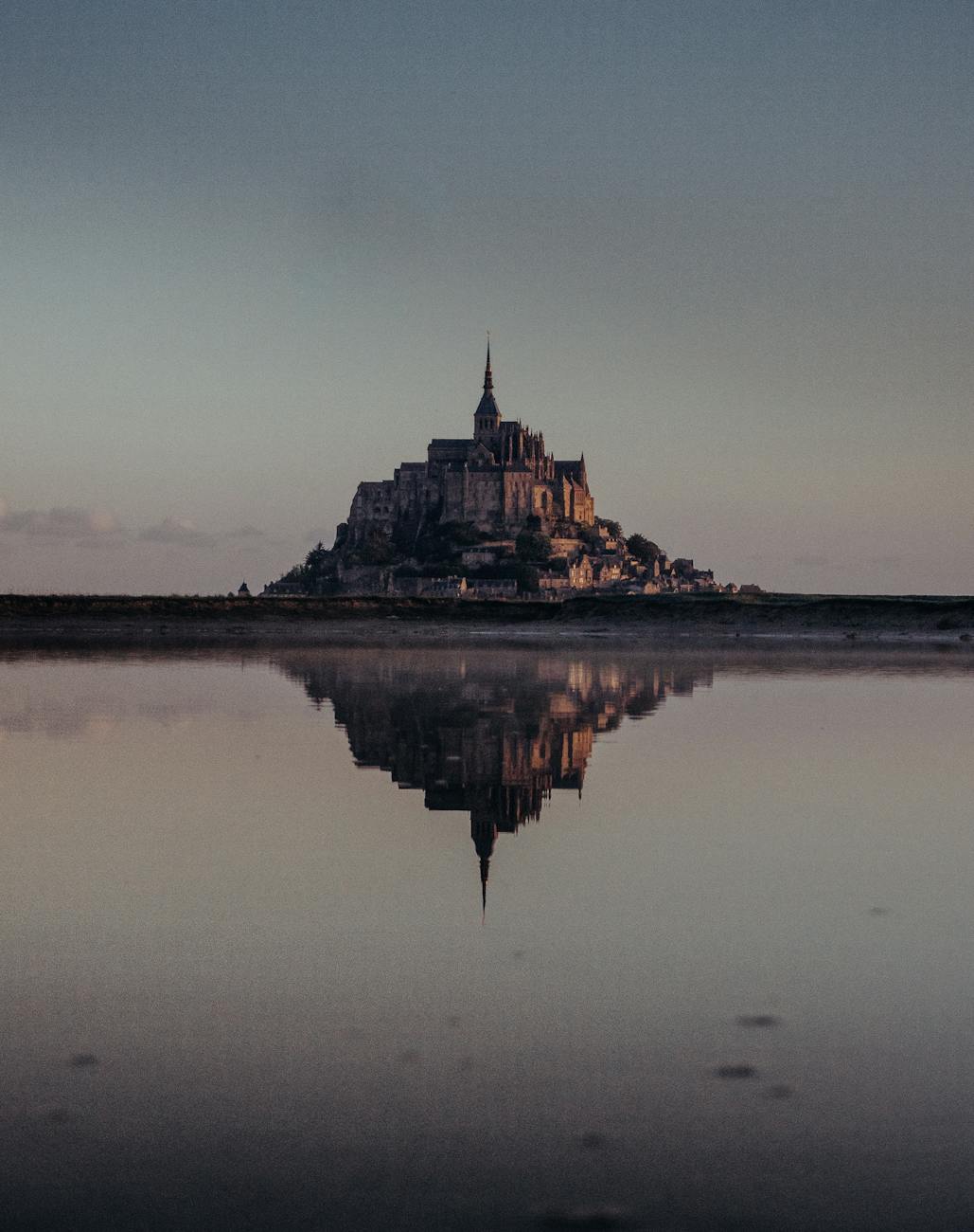 Mont Saint-Michel reflected in water at twilight in Normandy