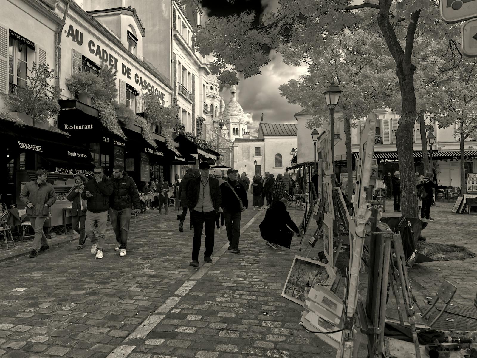 Street scene in Montmartre with Sacre-Coeur visible in the background Paris