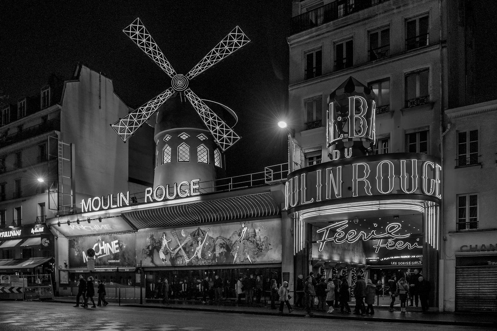 Black and white photograph of the Moulin Rouge at night in Paris