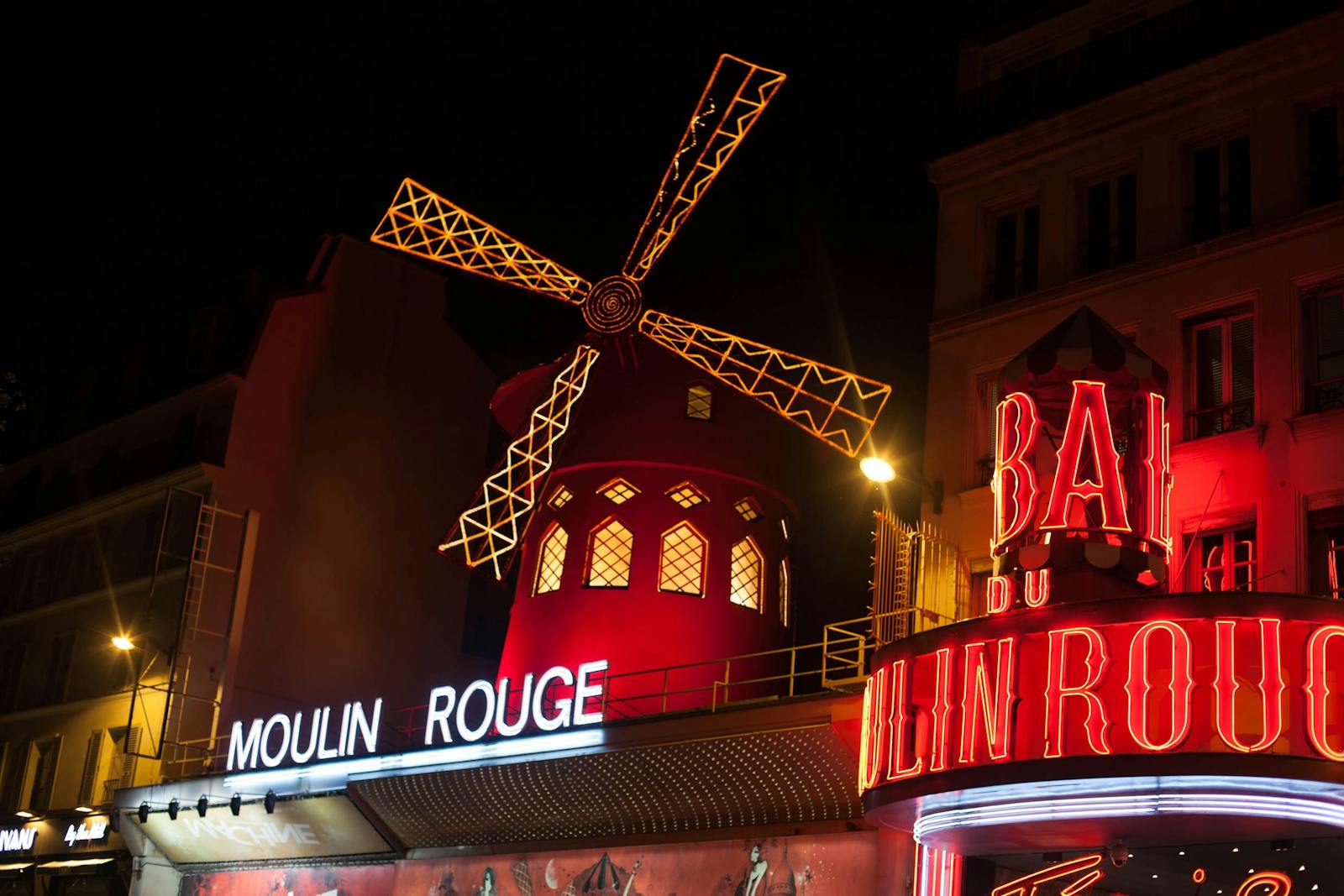 Brightly illuminated Moulin Rouge windmill in Paris at night