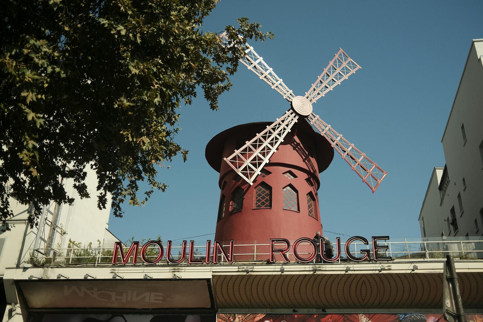 The famous Moulin Rouge windmill in Paris against a clear blue sky