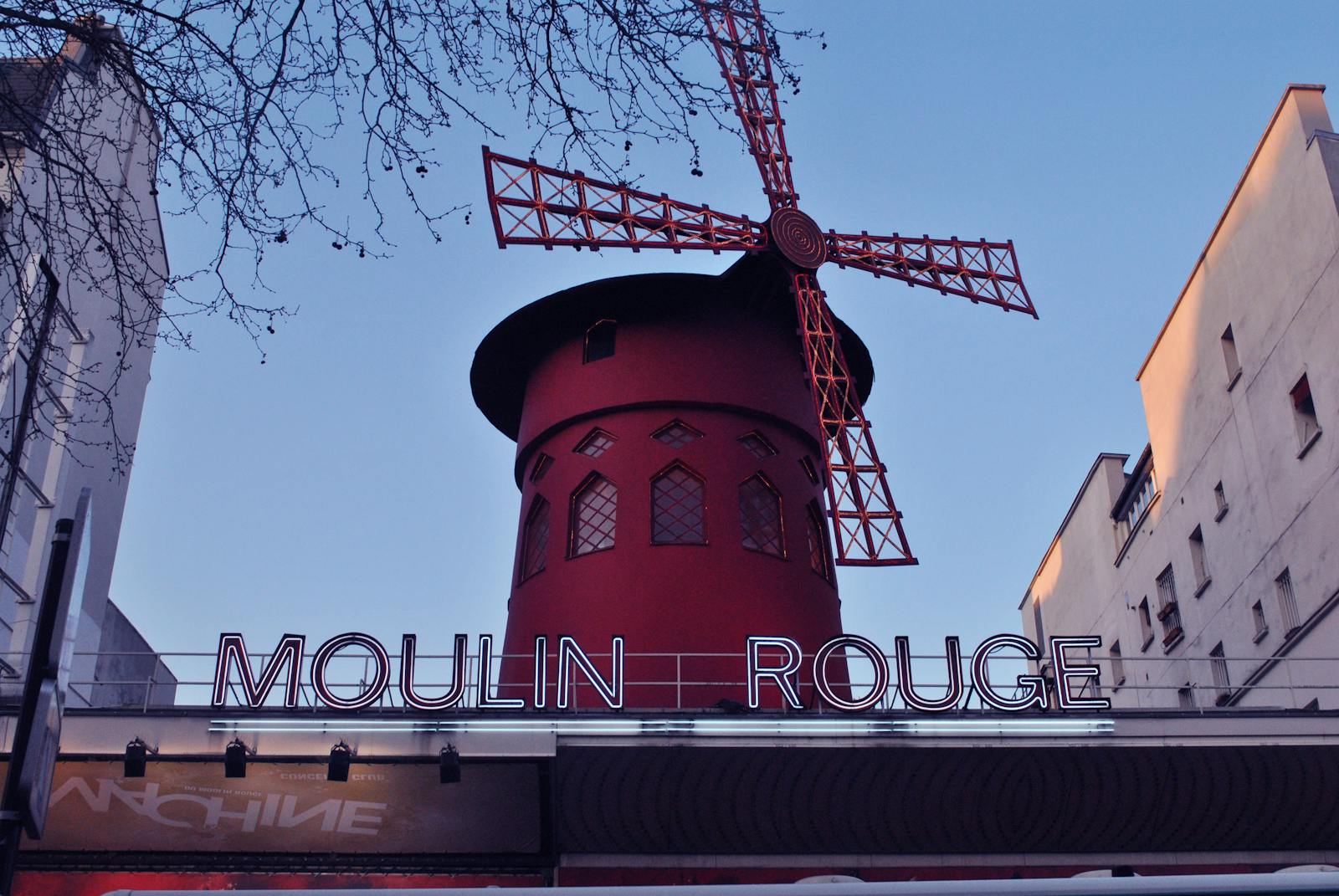 The Moulin Rouge windmill in Paris during the daytime with clear skies