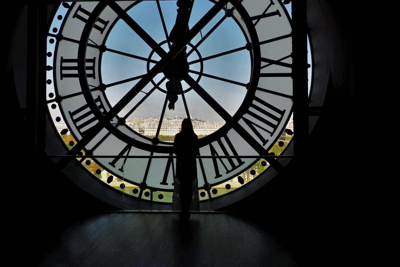 A silhouette of a person standing by the iconic Musée d'Orsay clock in Paris