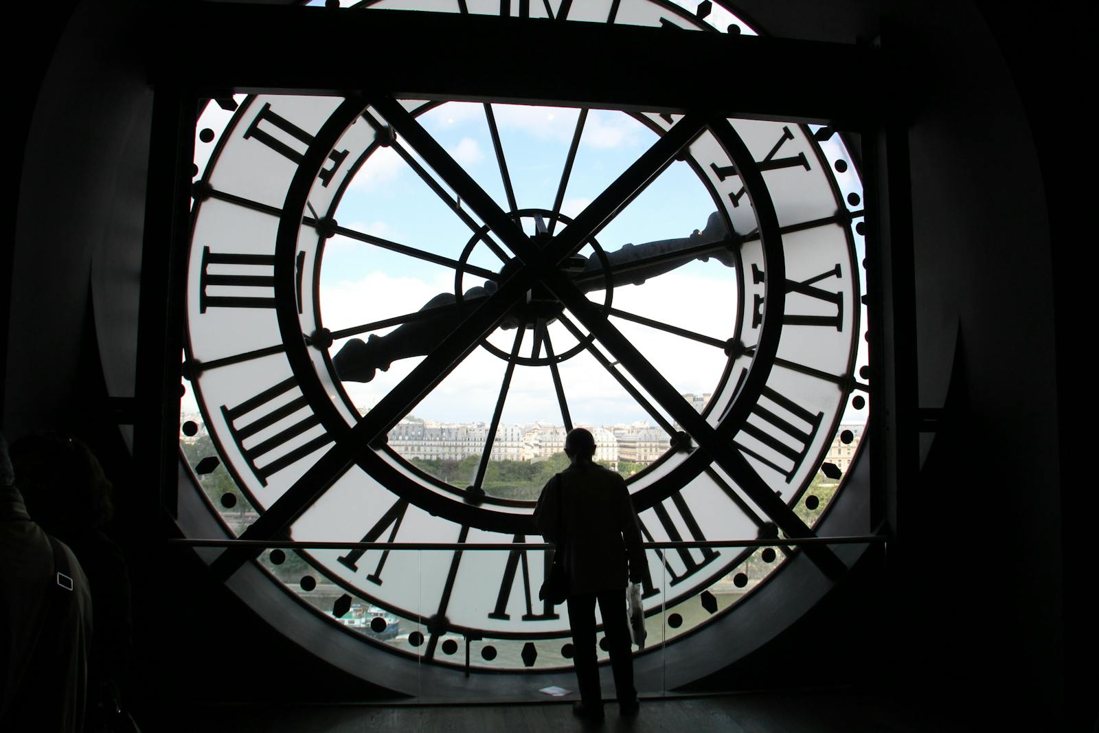 Silhouette standing inside the Musée d'Orsay clock overlooking Paris skyline