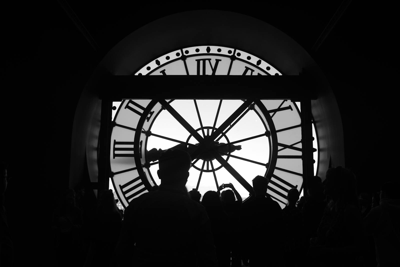 Silhouetted group of visitors in front of the iconic Musée d'Orsay clock