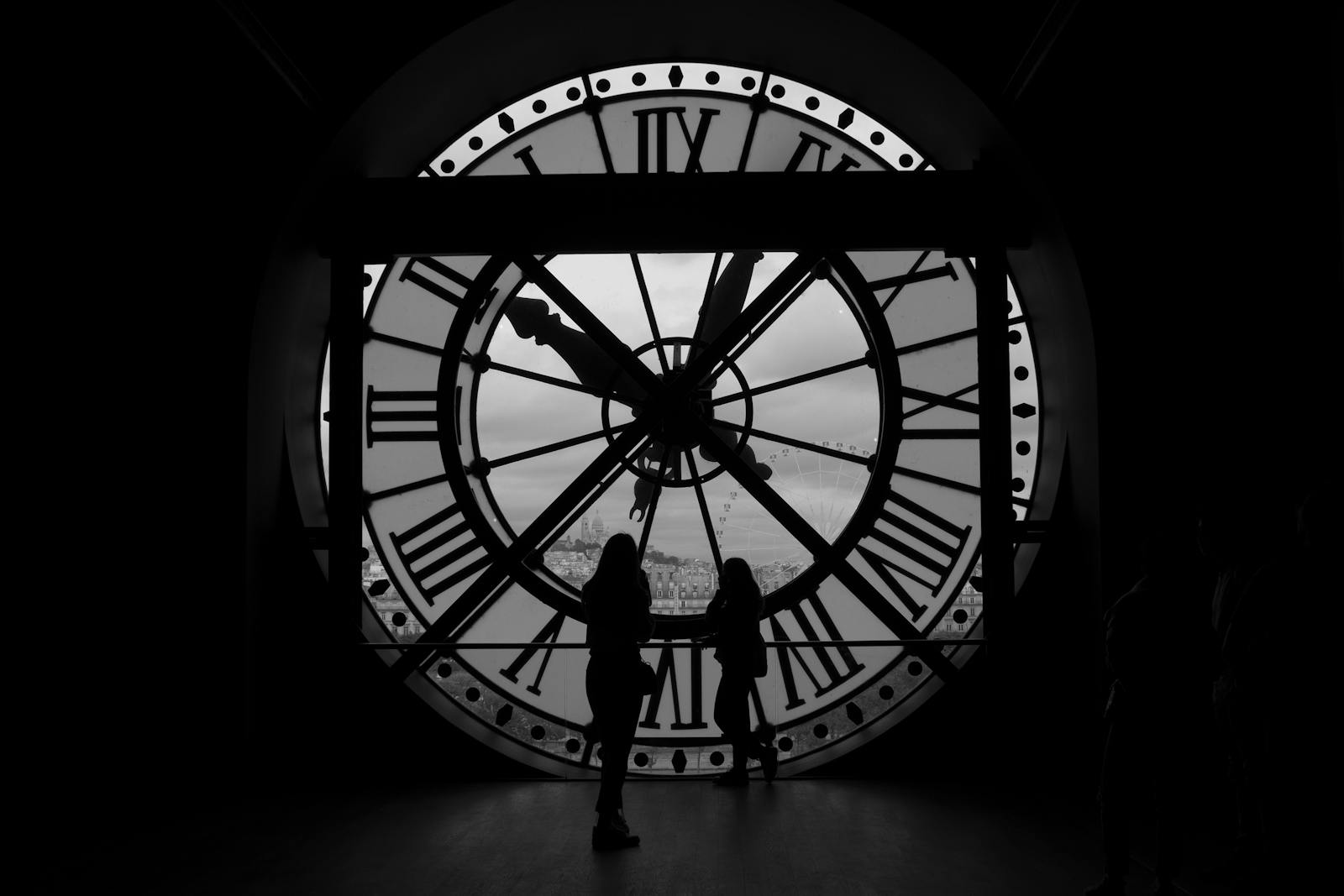 Silhouettes of people behind the famous Musée d'Orsay clock in Paris France