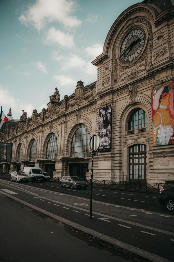 Musee d'Orsay facade with prominent clock and street scene in Paris