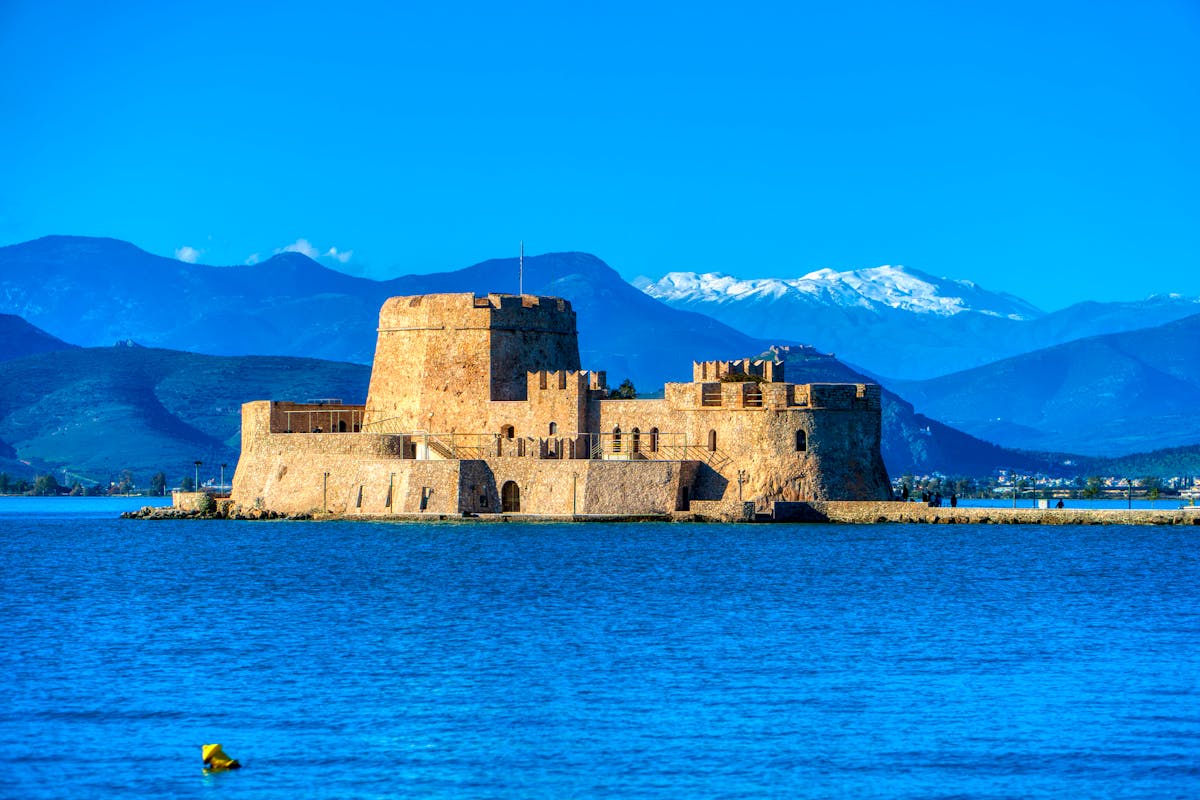 The Bourtzi castle fortress sitting on a small island in Nafplio harbor with mountains behind