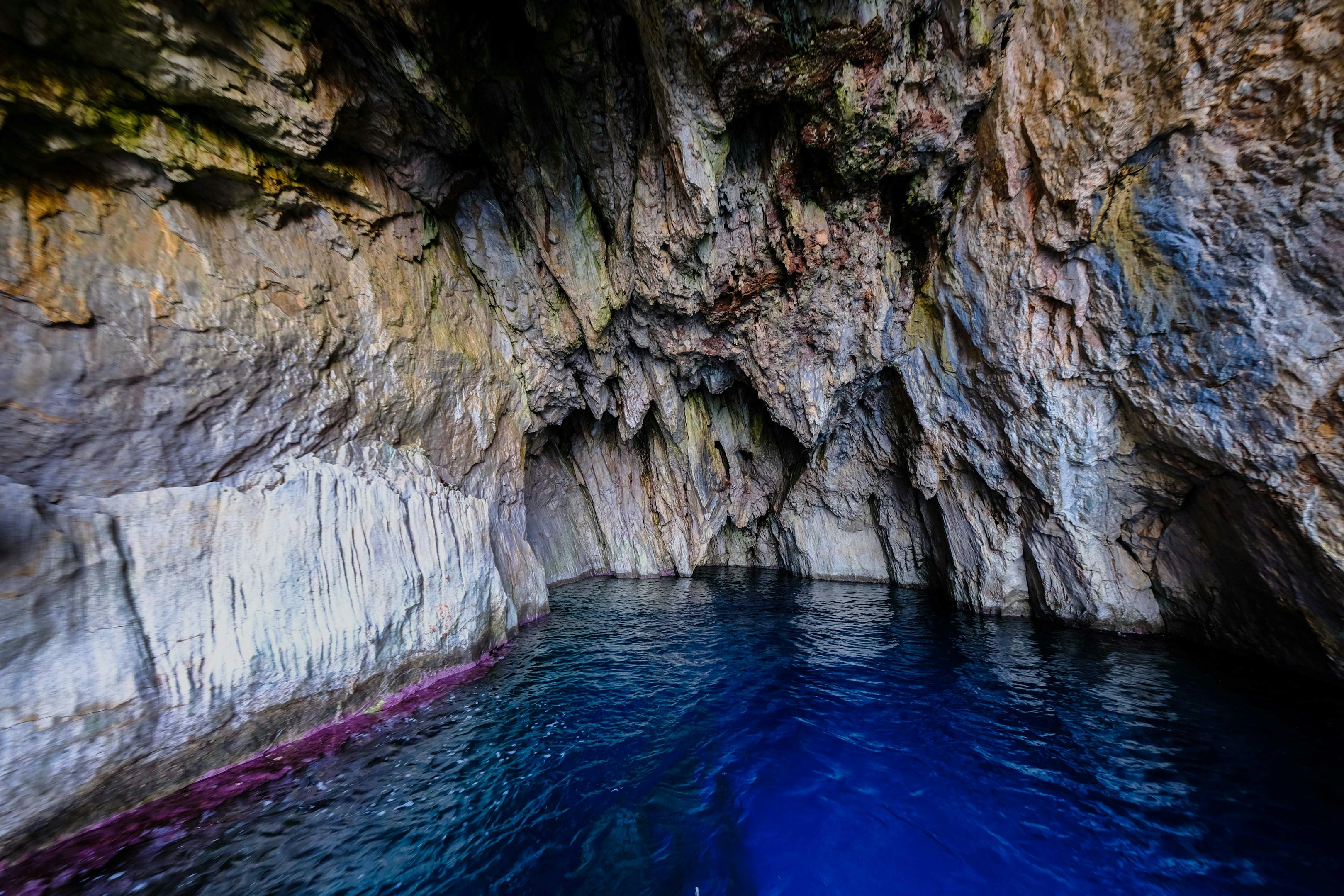 Experience the stunning beauty of a natural sea cave with vibrant blue waters and rocky textures