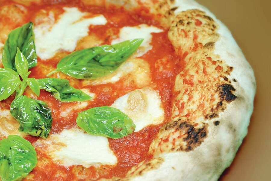 Freshly baked Neapolitan pizza with mozzarella and basil