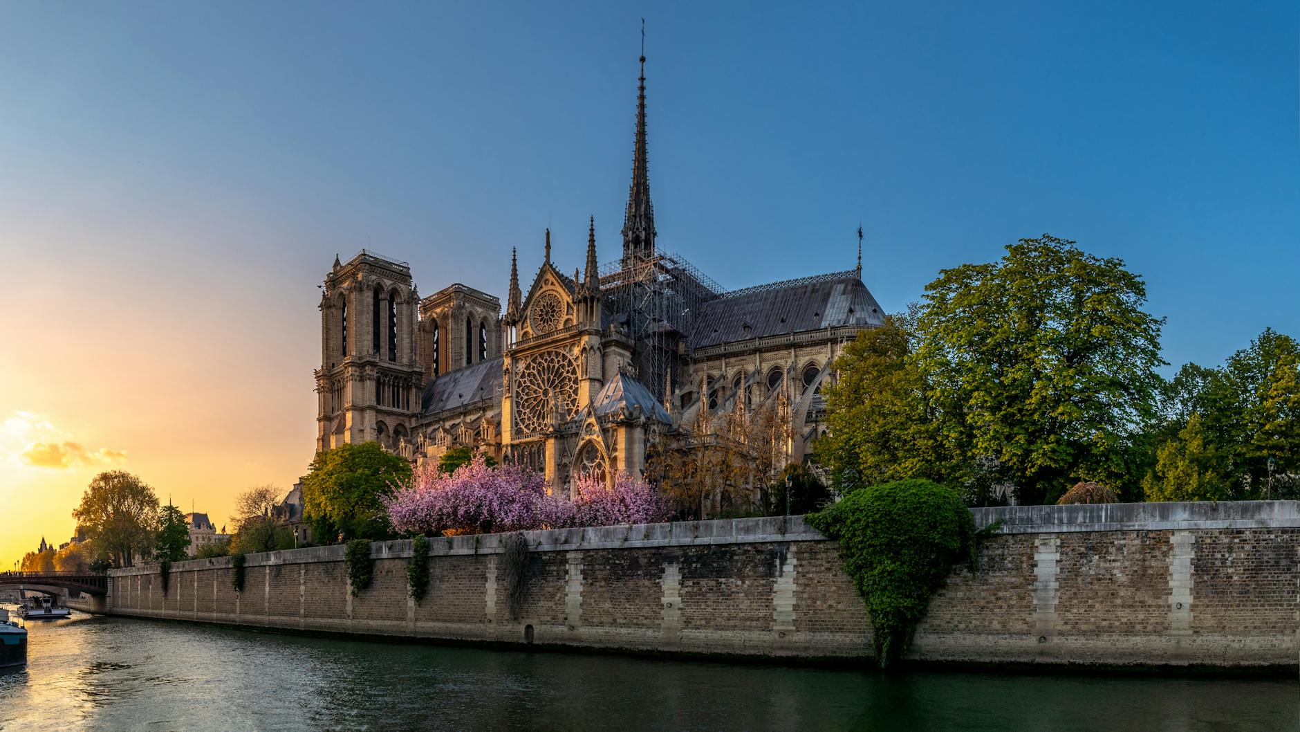 Notre-Dame cathedral bathed in warm sunset light over the Seine river