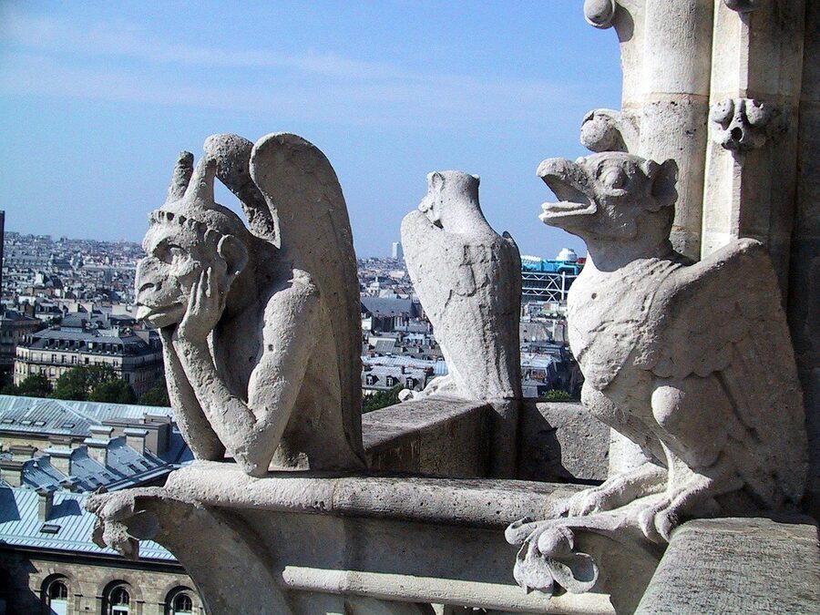 Gargoyle on Notre Dame Cathedral overlooking Paris rooftops