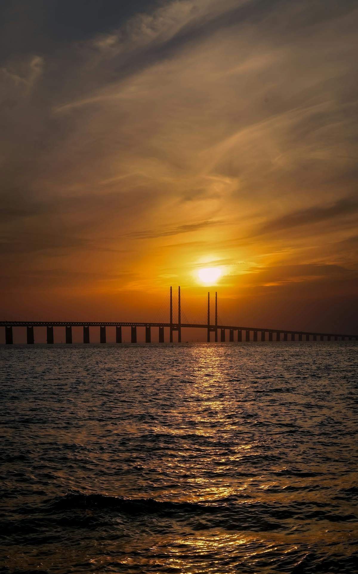 Golden sunset over the Øresund Bridge connecting Denmark and Sweden