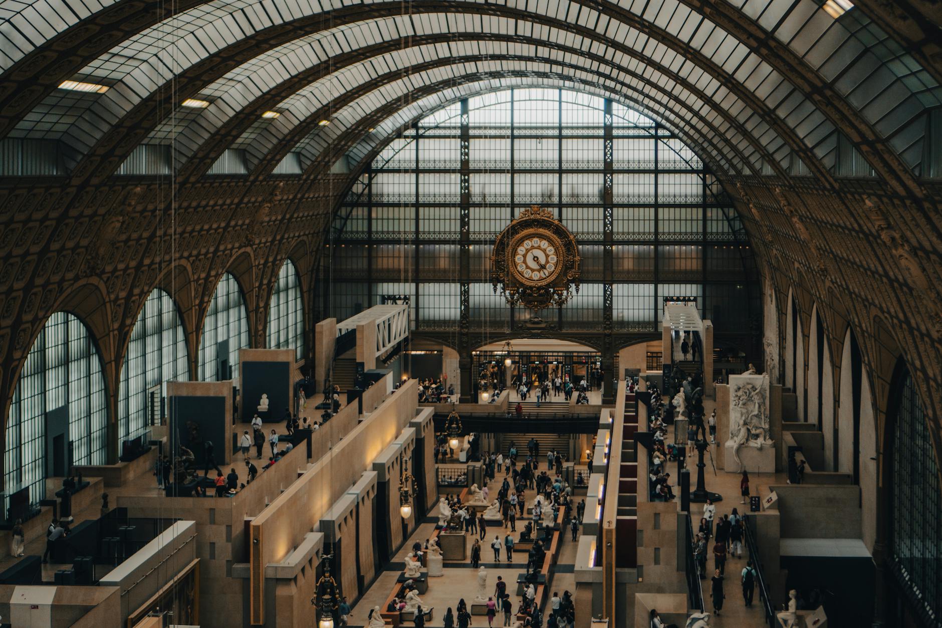 A gallery inside Musée d'Orsay featuring a historic clock and crowds of visitors