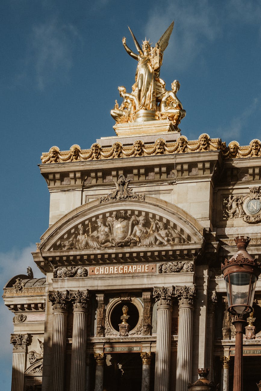 Palais Garnier ornate facade with golden statues against a blue sky