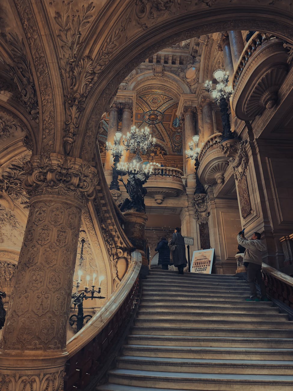 Detailed view of grand staircase inside Palais Garnier with intricate marble
