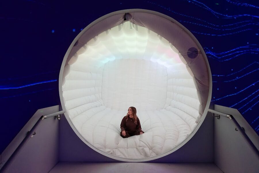 Woman seated futuristic illuminated capsule