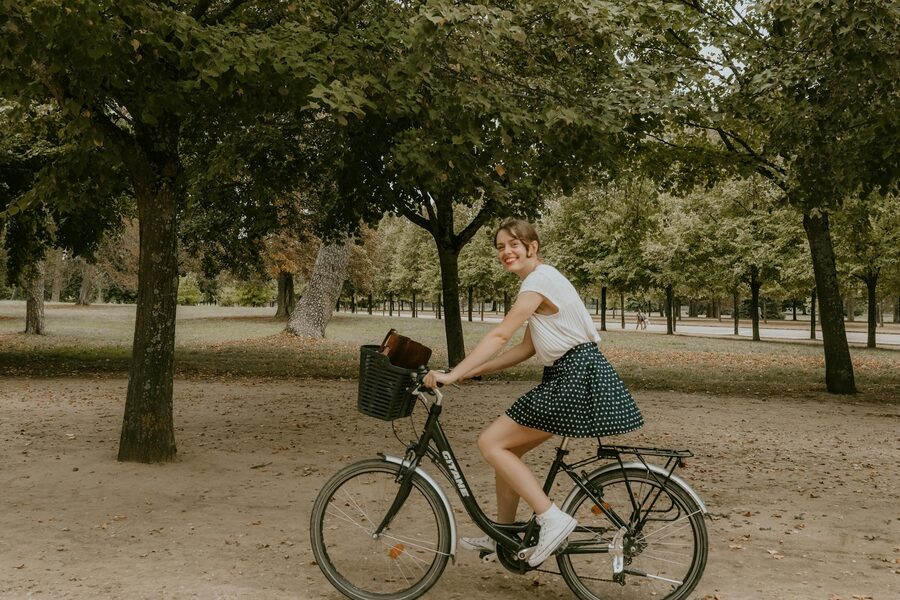 Young woman riding a bicycle in a beautiful Paris park