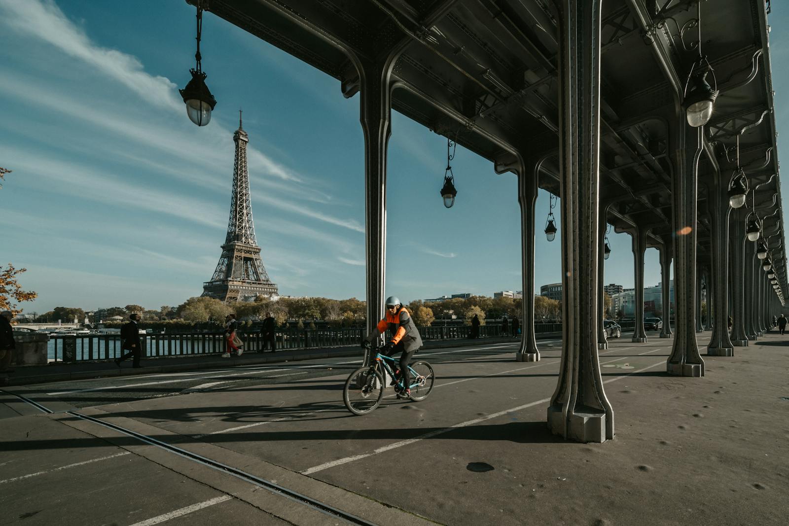 Cyclist riding under Pont de Bir-Hakeim with the Eiffel Tower in the background in Paris