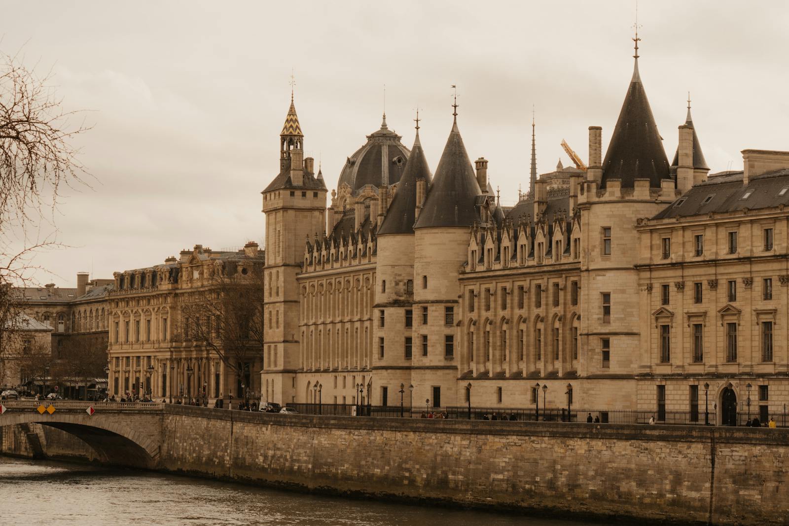Historic Conciergerie in Paris along the Seine River showing gothic riverside architecture