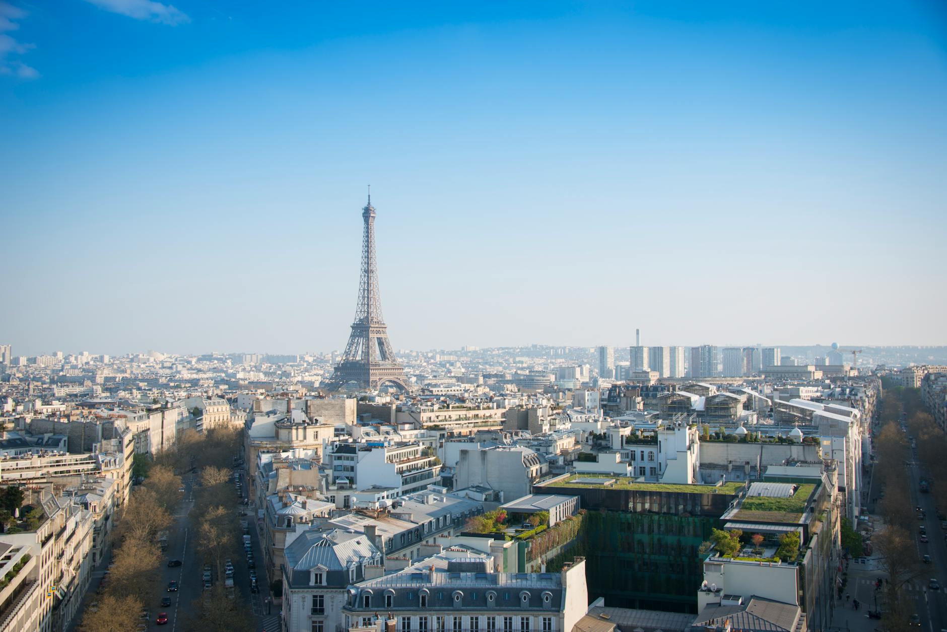 Wide aerial view of central Paris with the Eiffel Tower surrounded by Haussmann architecture