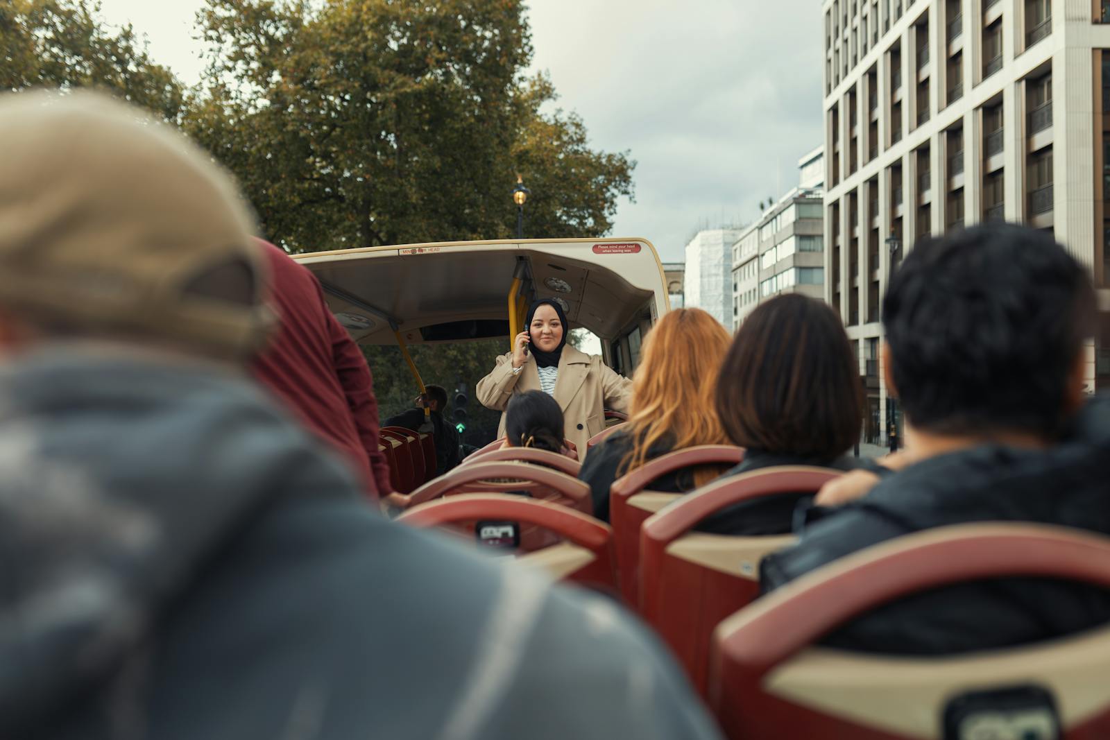 Diverse group of travelers enjoying an open-top bus tour through a Paris street