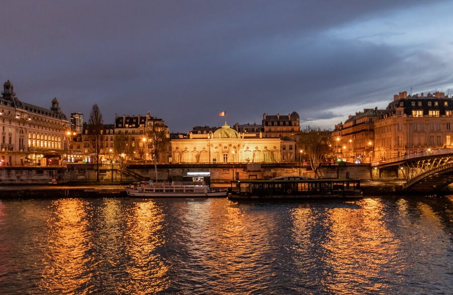 Illuminated Parisian landmarks and bridges reflecting in the Seine at night