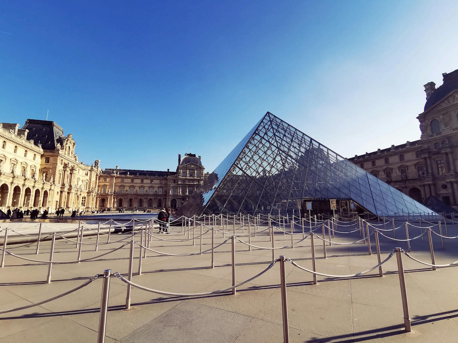 Louvre Pyramid glass structure under a bright Paris sky