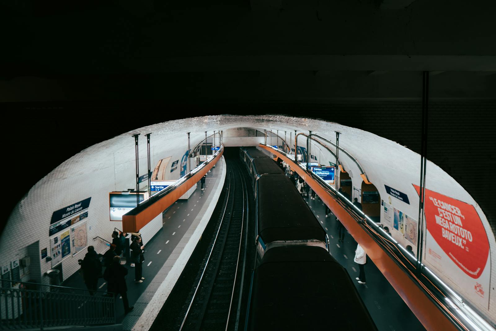 Busy Paris Metro station with commuters waiting on the platform