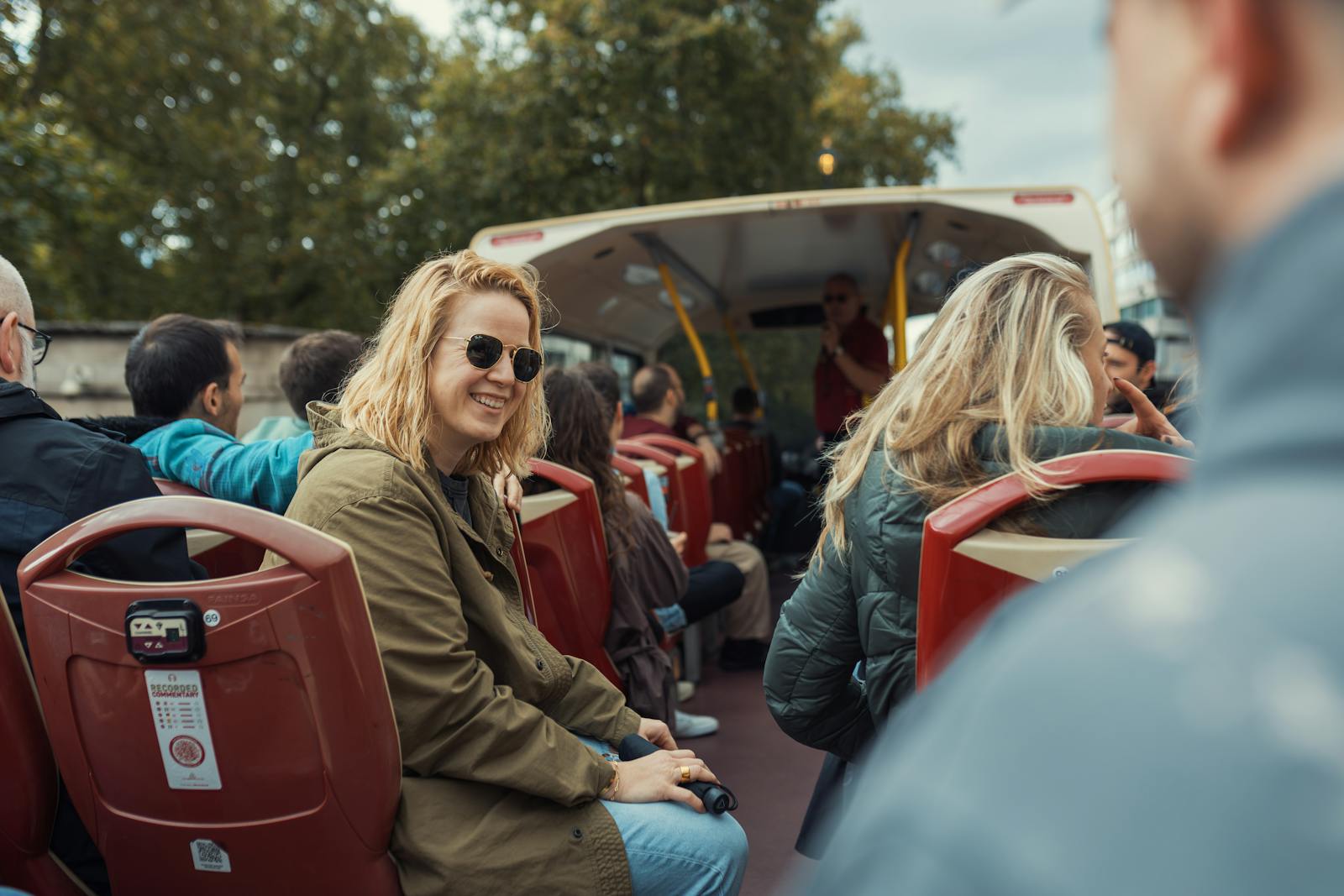Passengers on an open-top Paris sightseeing bus during a city tour