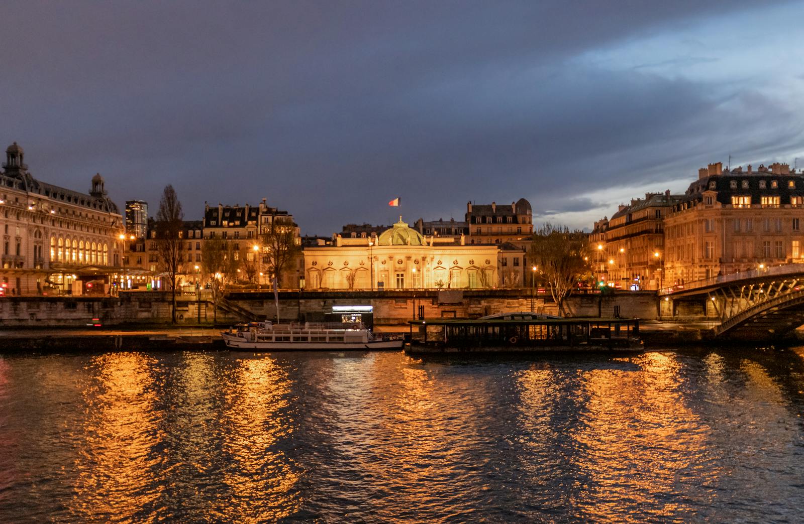 Illuminated Paris bridges reflecting in the Seine River at night