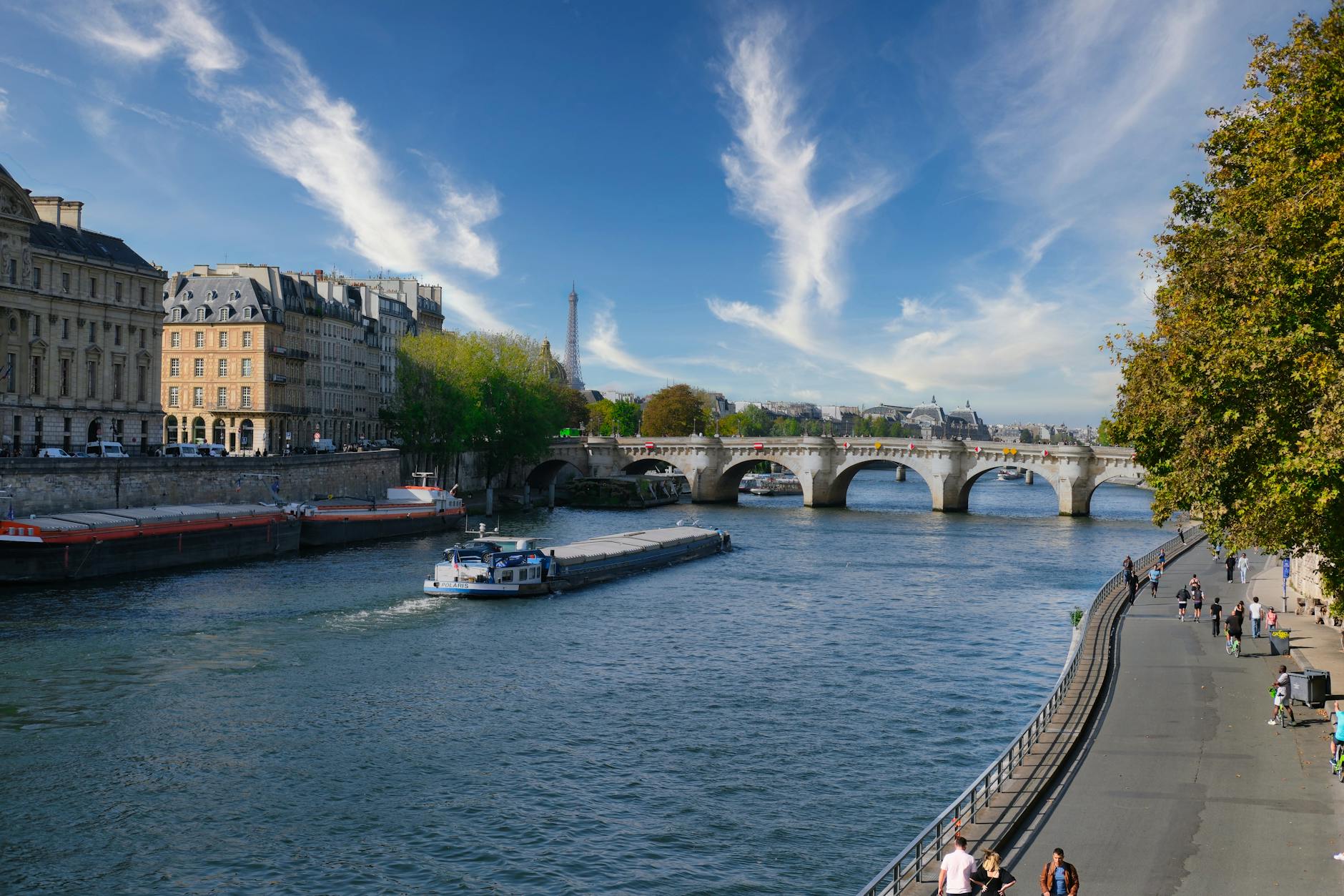 The Seine river with Paris historic architecture and the Eiffel Tower under blue sky