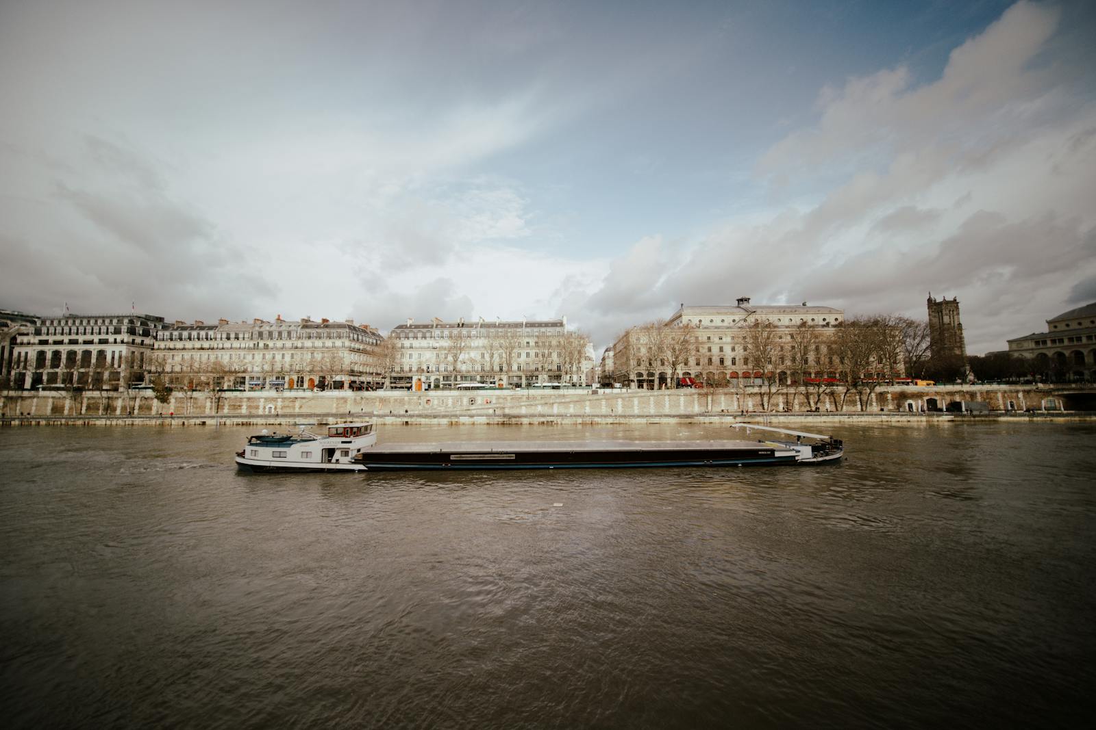 Elegant cruise boat on the Seine River with Paris buildings in the background