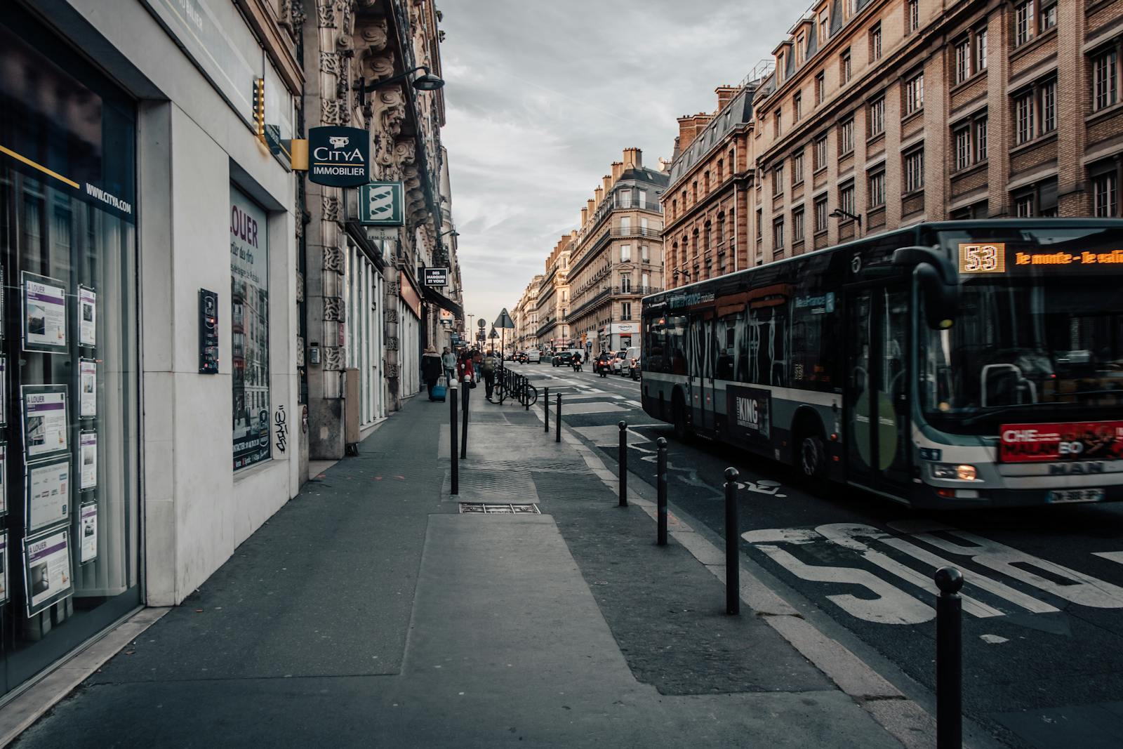 Paris street view with a sightseeing bus passing historic Haussmann buildings