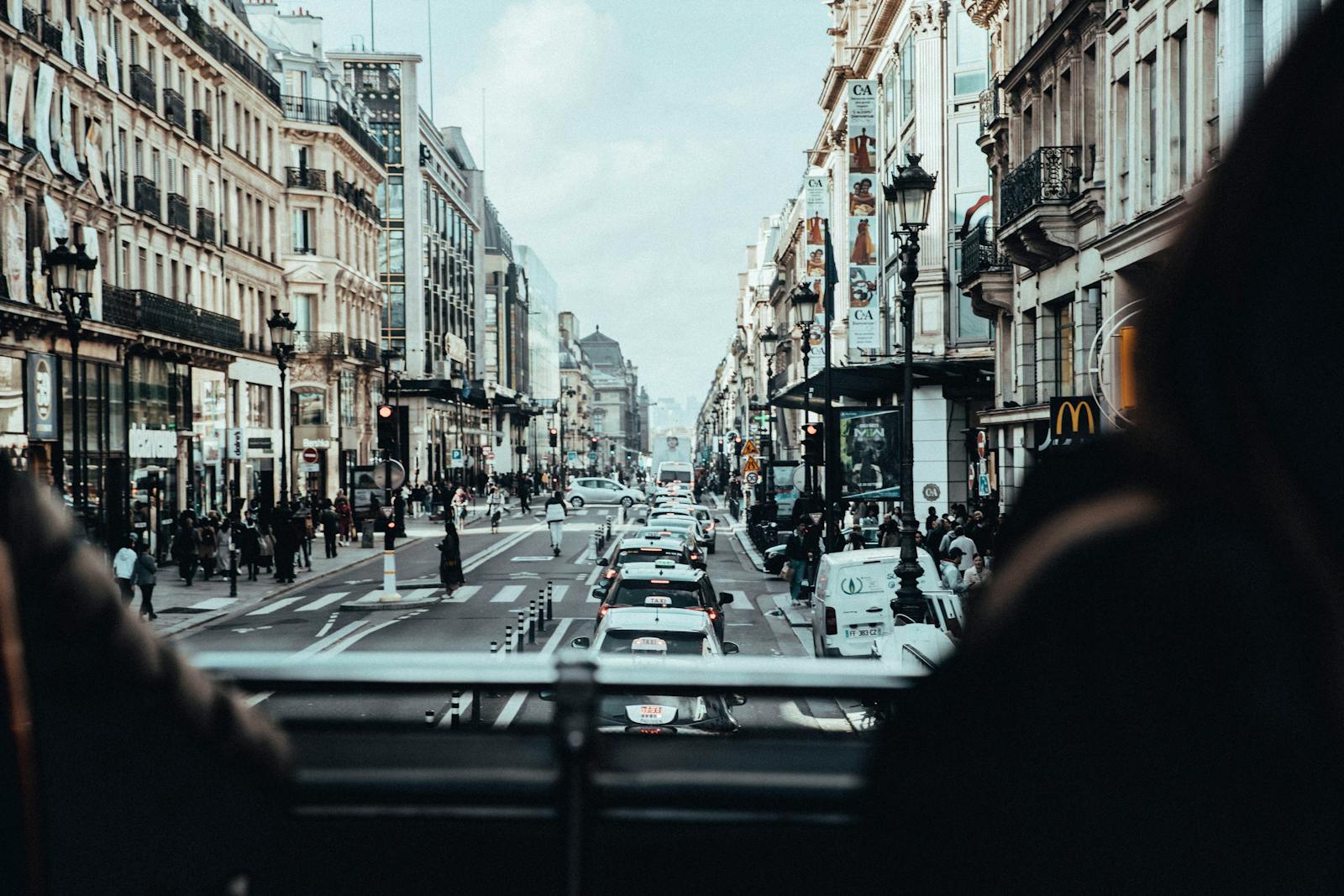 Busy Paris street scene with cars, pedestrians, and classic architecture