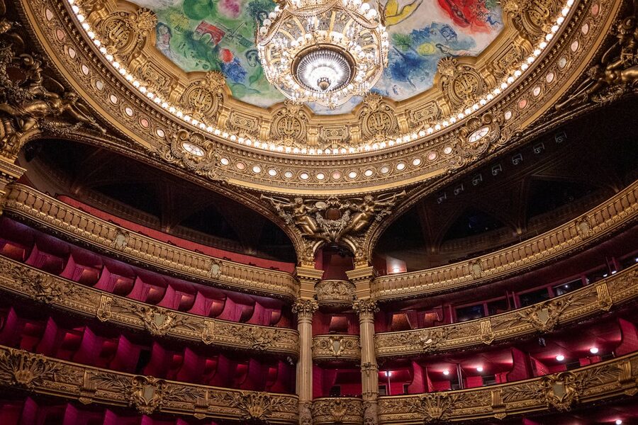 Luxurious Paris theater interior with ornate gold details and chandelier