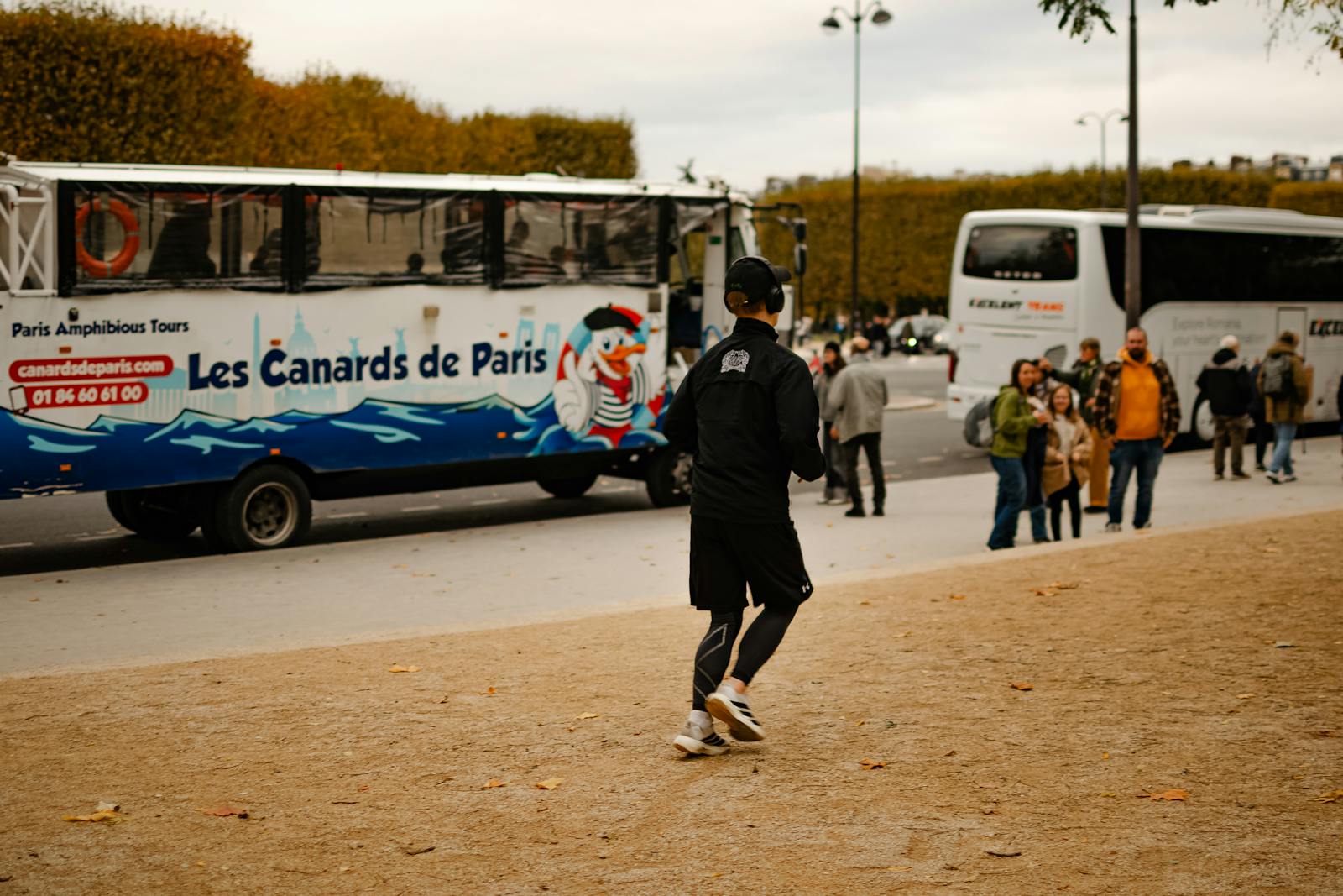 Paris tour buses parked on a city street framed by autumn foliage