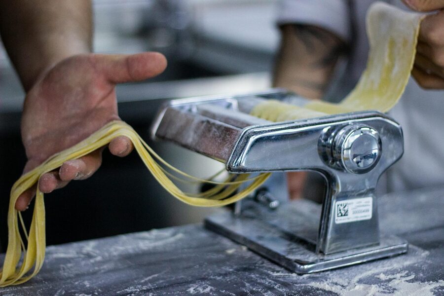 Fresh pasta being prepared with a manual pasta machine