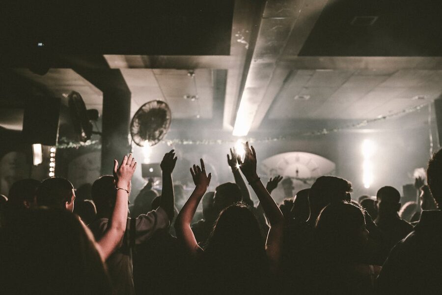 People dancing with raised arms at a nightclub