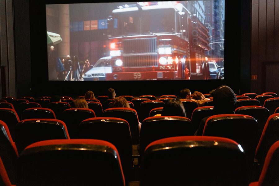 People seated watching a movie on a large cinema screen