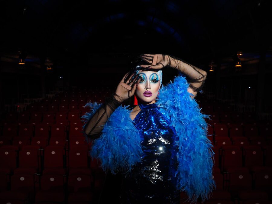 Glamorous performer in feather costume on theater stage