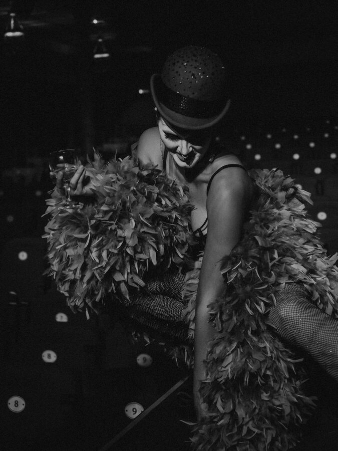 Cabaret performer in feathers exuding glamour in black and white