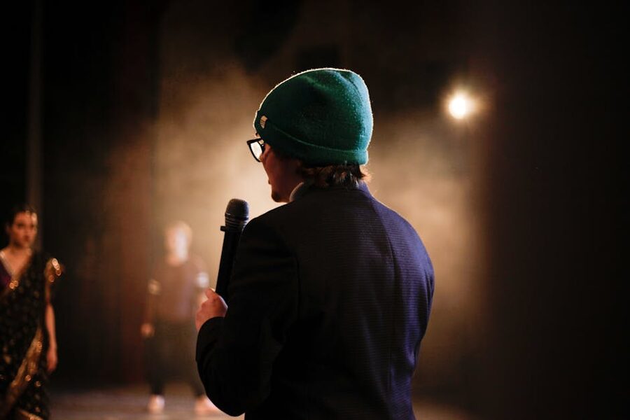 Performer with microphone under moody spotlight