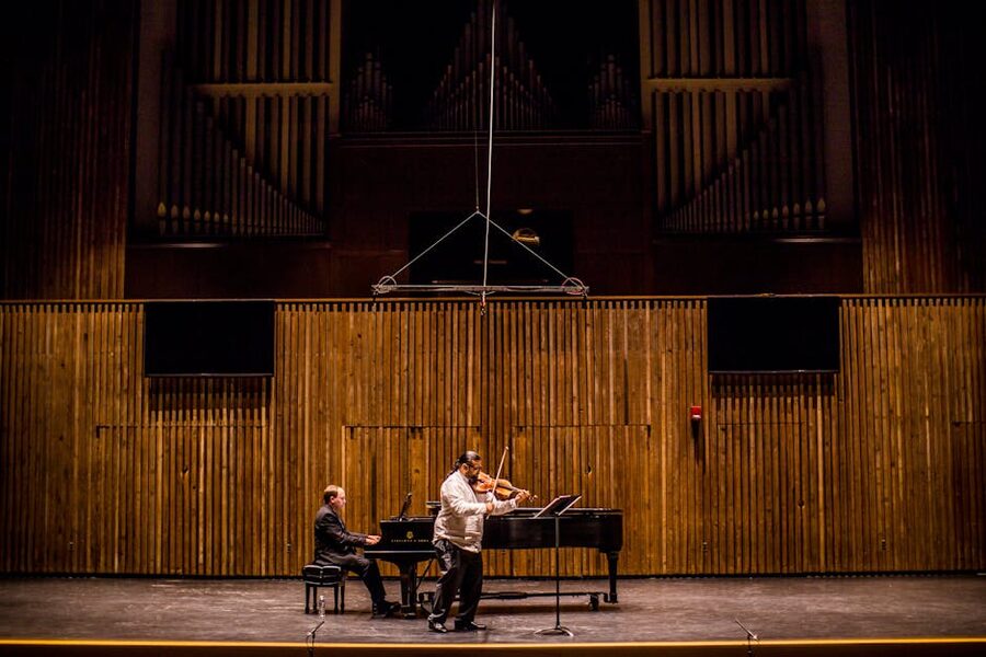 Piano violin musicians in concert hall