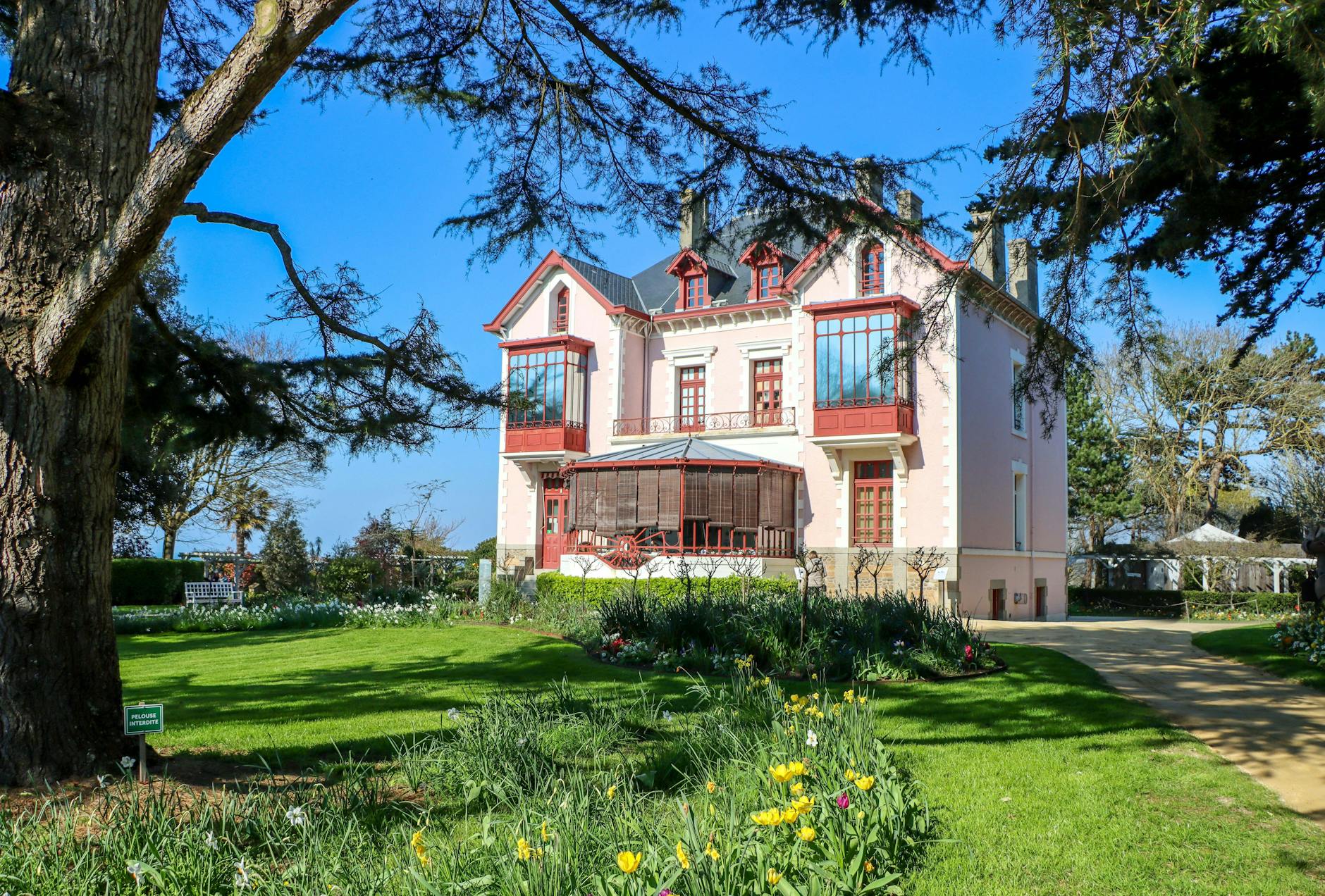 Charming pink Victorian house surrounded by lush garden