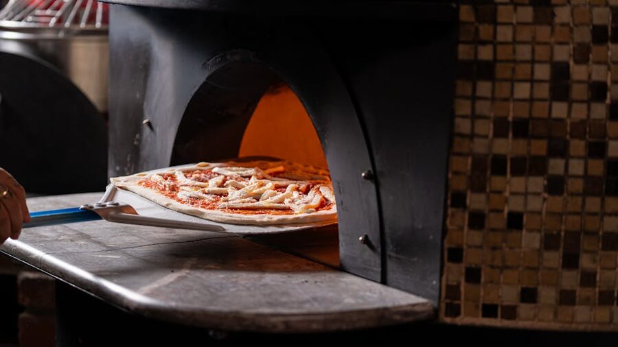 Artisan pizza entering wood-fired oven