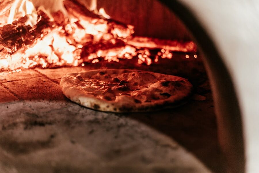 Pizza baking in traditional wood-fired oven