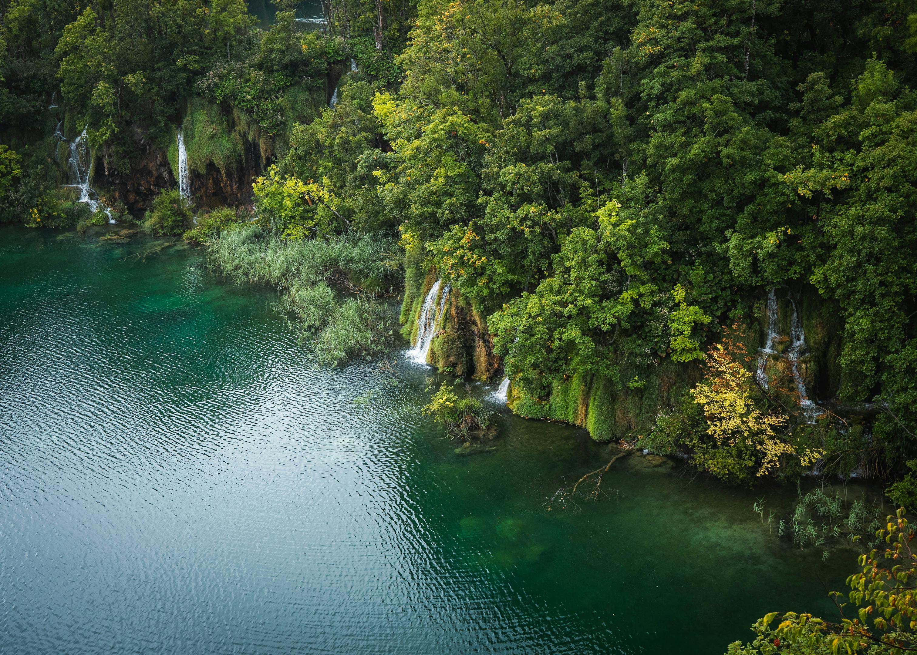 Aerial view of lush waterfalls and turquoise waters in Plitvice Lakes, Croatia